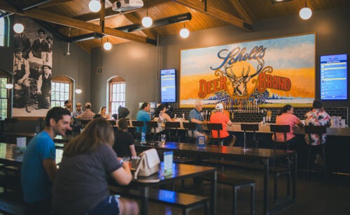 People sitting at tables and at the bar in the Schell's Brewery Bierhalle.